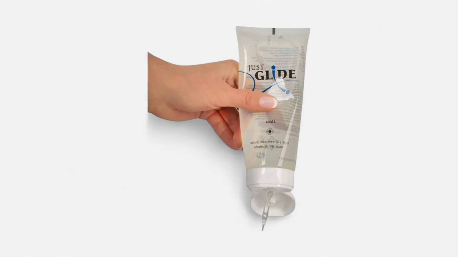 HU: Just Glide Anal síkosító tubus kézben, nyitott kupakkal és adagolt géllel EN: Just Glide Anal lubricant tube held in hand with open cap and dispensed gel