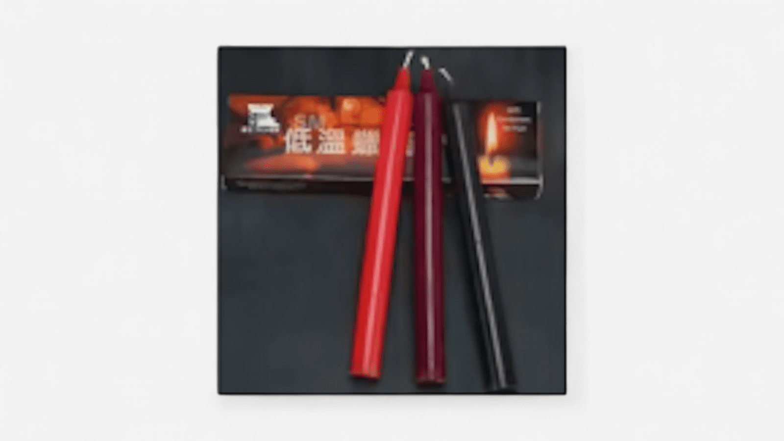 Alacsony hőmérsékletű viaszgyertyák piros, bordó és fekete színben, csomagolással együtt. EN: Low temperature wax candles in red, burgundy and black with product packaging shown.