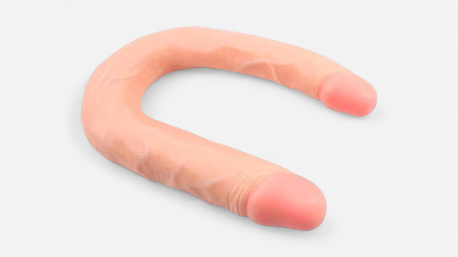 HU: Kétszer Kérem ívelt kétvégű dildó ferde nézetből, puha PVC anyaggal és testszínű felülettel EN: Kétszer Kérem curved double-ended dildo angled view with soft PVC material and flesh-colored finish