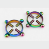 HU: Csöcscsavar szivárványos mellbimbóbilincs pár, négy állítható csavarral, elölnézetben világosszürke háttéren. EN: Titty Torque rainbow nipple clamp pair with four adjustable screws, front view on a light grey background.