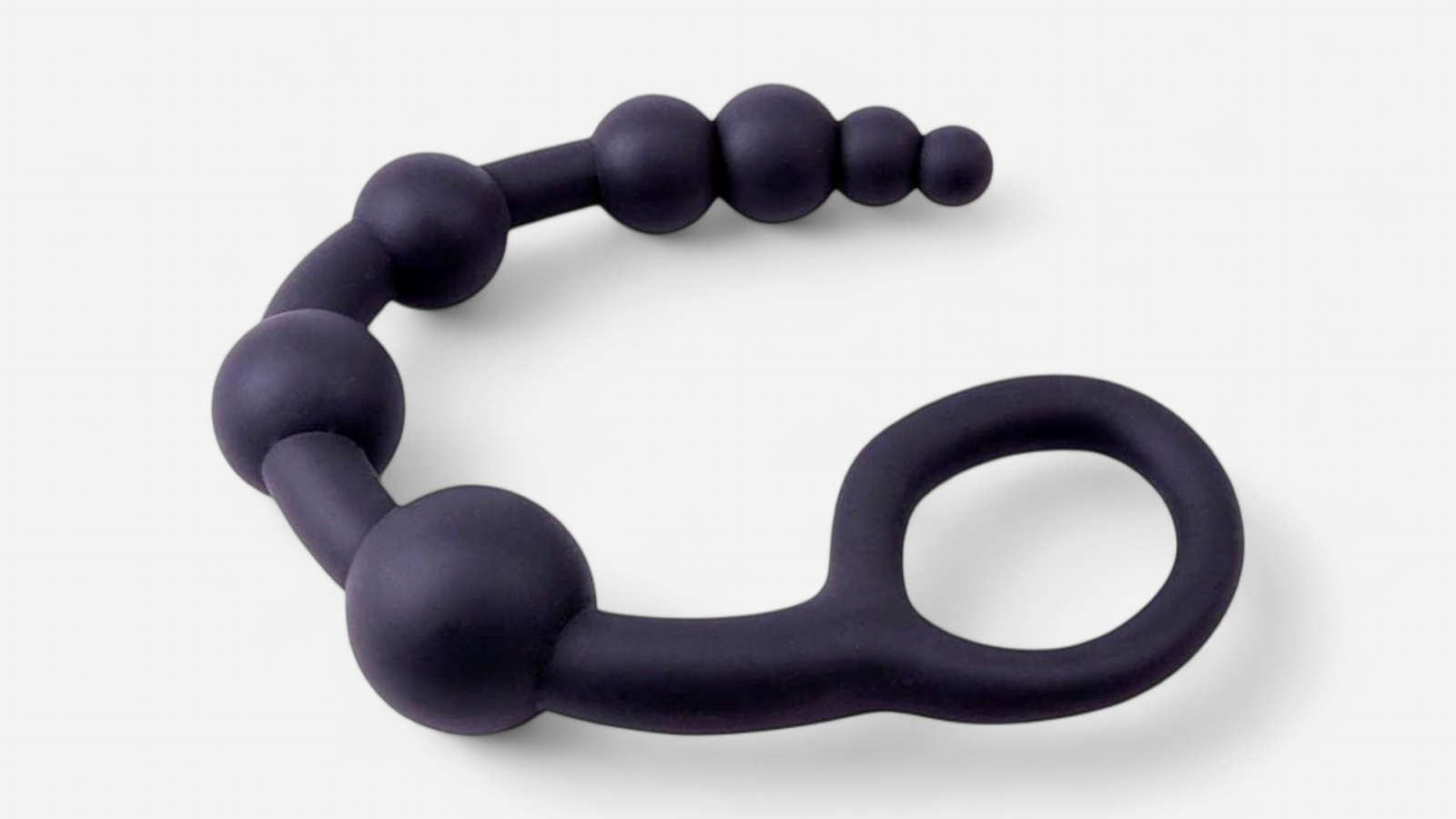 HU: Hosszú fekete anál gyöngysor rugalmas kialakítással, szóló és páros használatra. Fekvõ nézetben. EN: Long black anal bead chain with a flexible design for solo or couple play. Laying on one side.